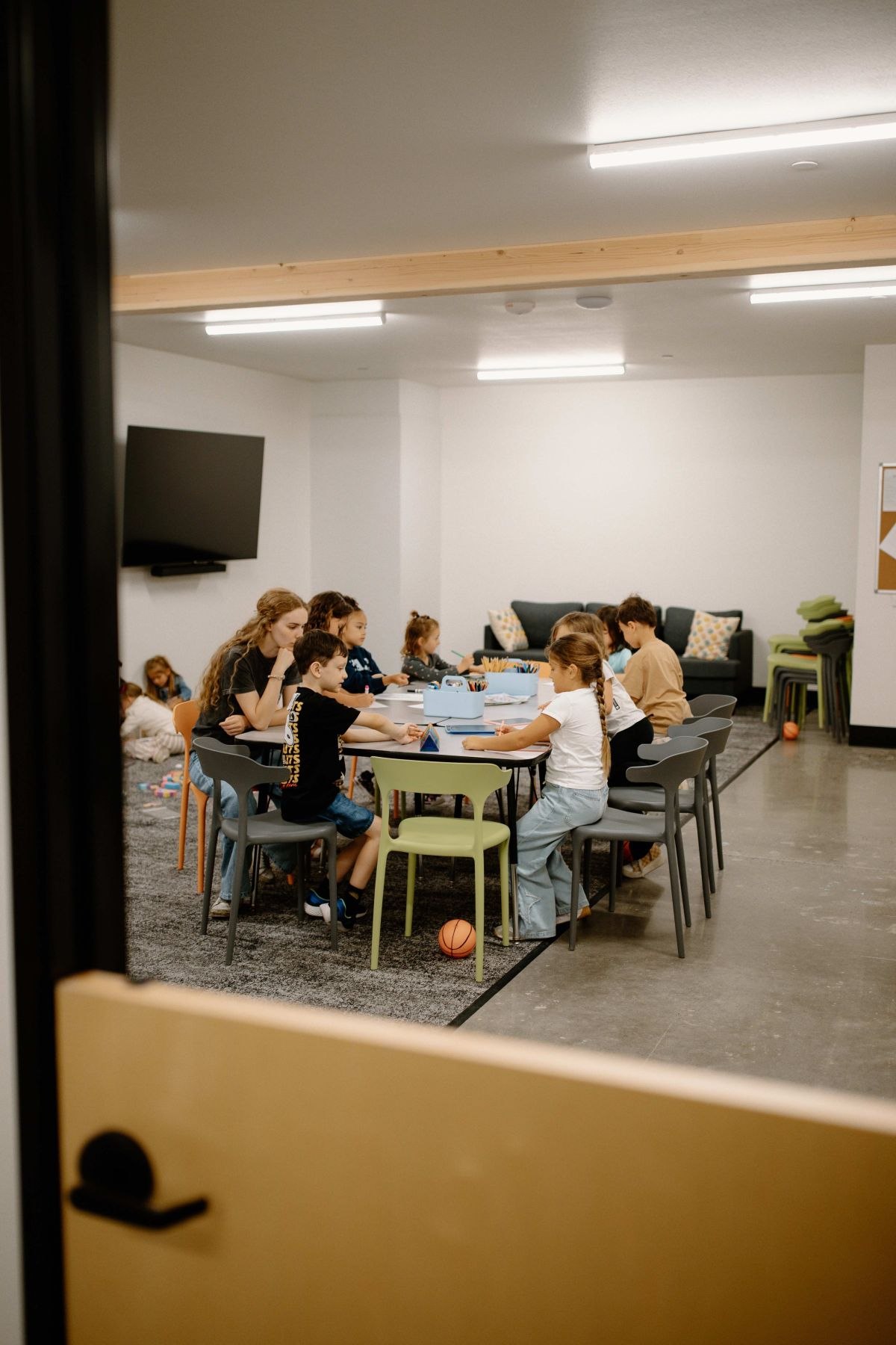 Children and a leader connecting around a table in a Rise Kids classroom