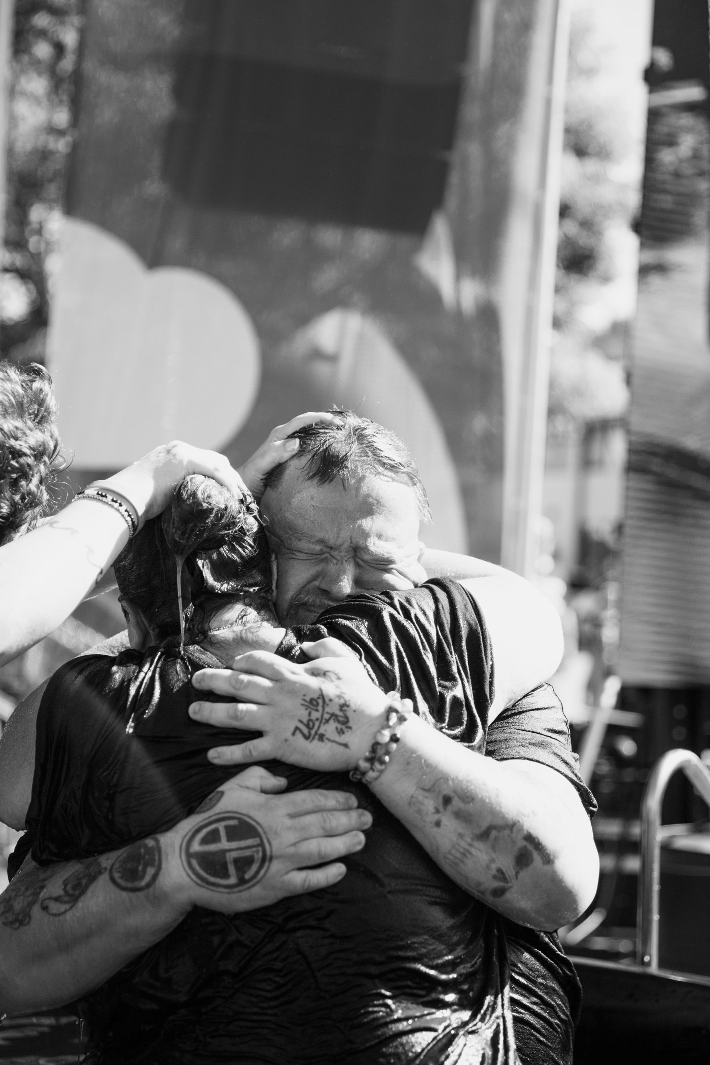 An embrace in the baptism waters at Rise