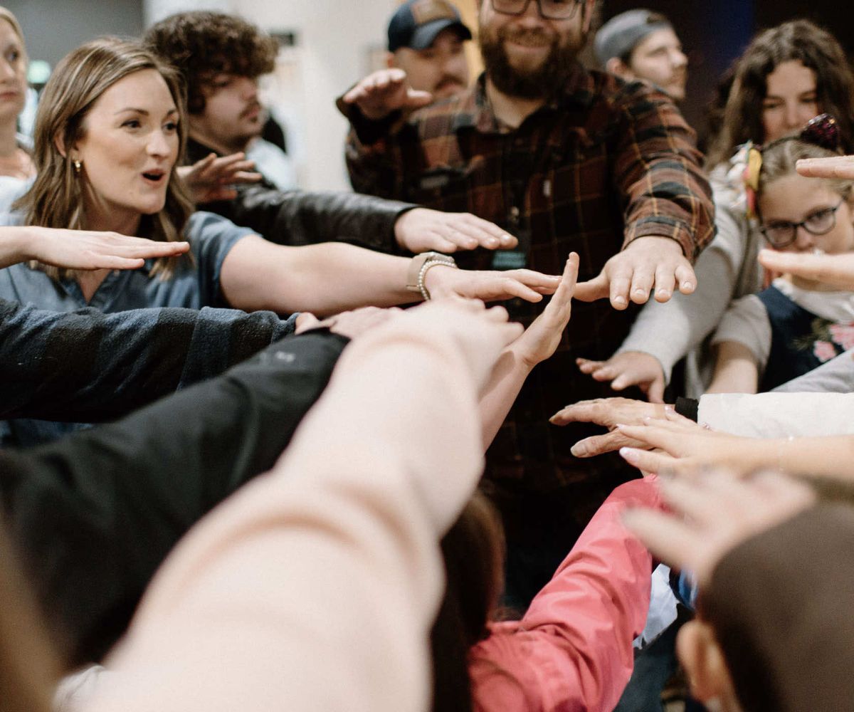 Rise team members bringing their hands together in a team huddle
